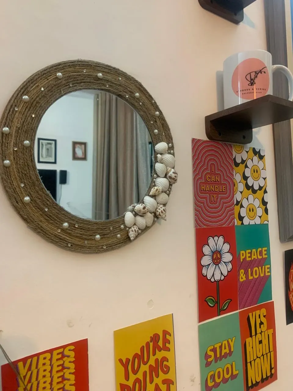 A round jute rope mirror decorated with pearls and shells on the studio wall