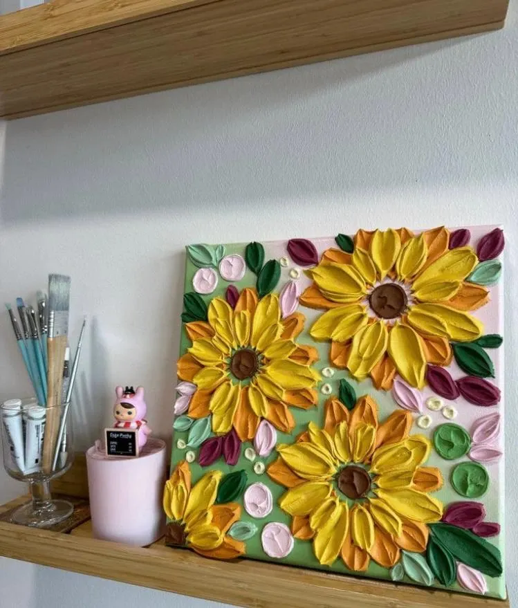 Thick impasto sunflowers on a square canvas on a wooden shelf